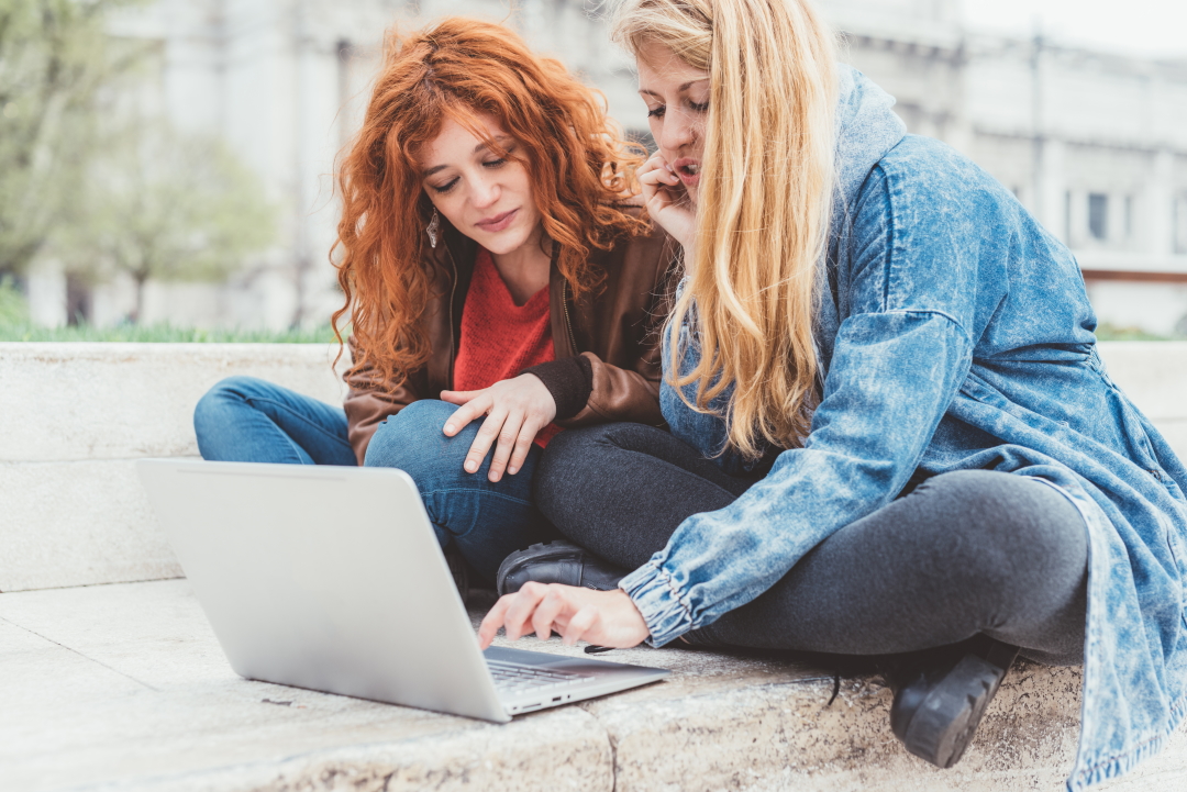 Bestie1 Two young women friends using computer working outdoor - business, studying, technology concept