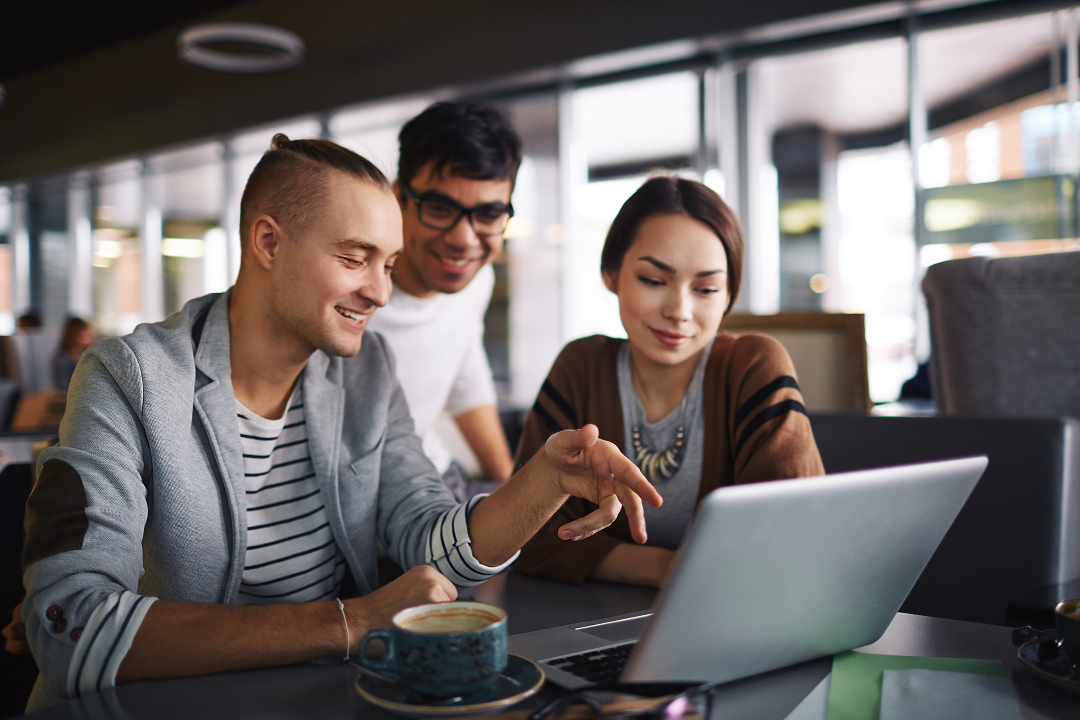 Group of friends with laptop spending leisure in cafe